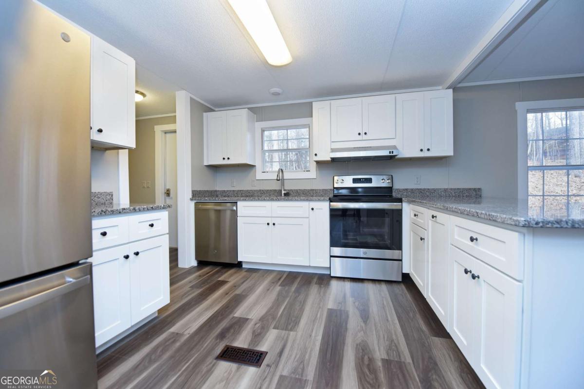 273 Rose Ray Road Ellijay, GA 30540 - Photo 3 of 32 a kitchen with white cabinets stainless steel appliances and sink