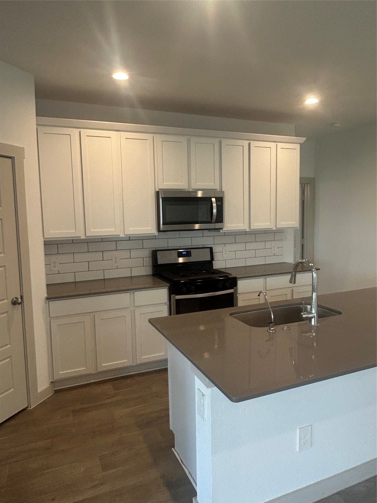 215 Dusty Bridle Lane Rosharon, TX 77583 - Photo 5 of 15 a kitchen with sink a microwave and cabinets