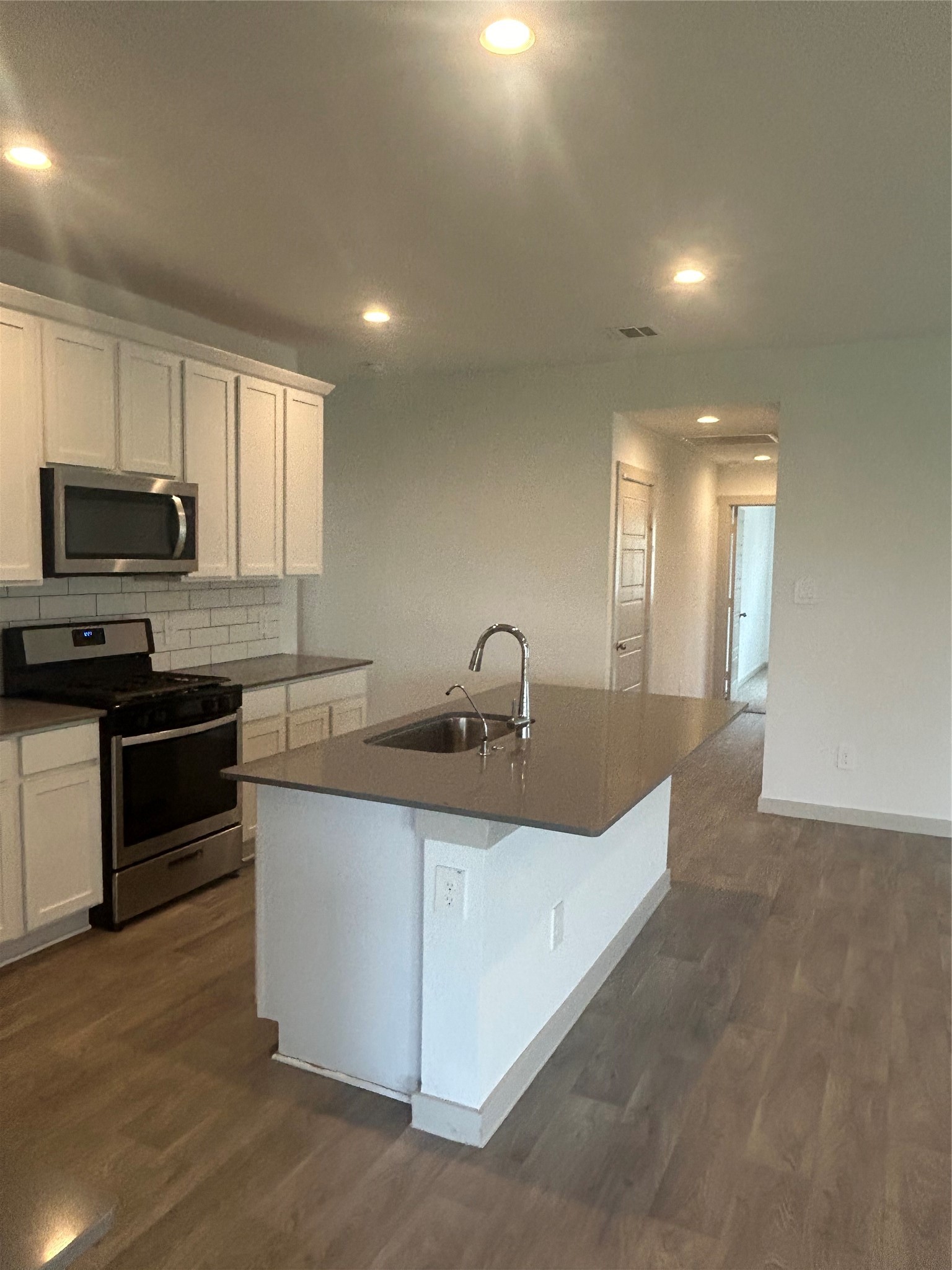 215 Dusty Bridle Lane Rosharon, TX 77583 - Photo 6 of 15 a kitchen with stainless steel appliances granite countertop a sink and a microwave