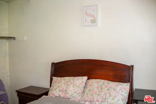 a bedroom with a bed and a painting on the wall