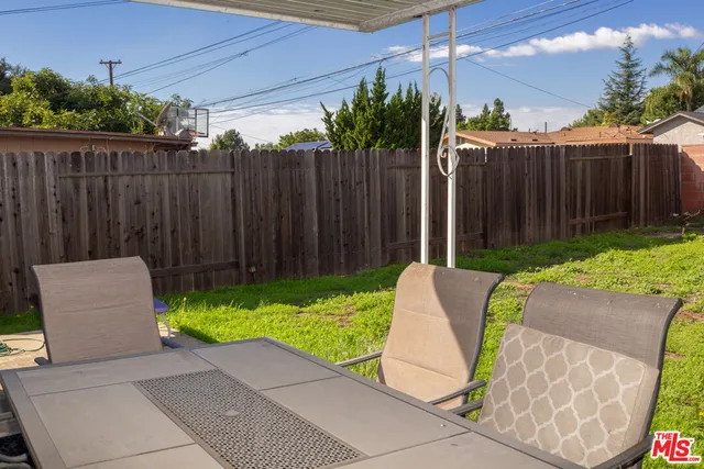 a view of backyard with table and chairs