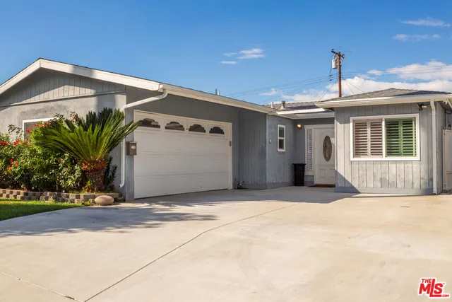 a front view of a house with plants