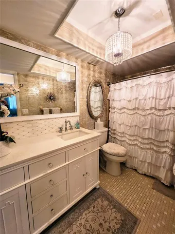 a bathroom with a granite countertop toilet sink and mirror