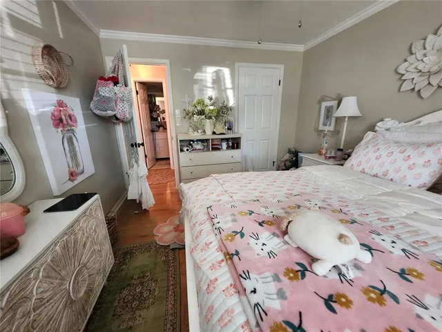 a bedroom with bed and wooden floor
