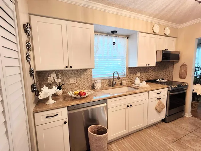 a kitchen with stainless steel appliances granite countertop a sink stove and cabinets