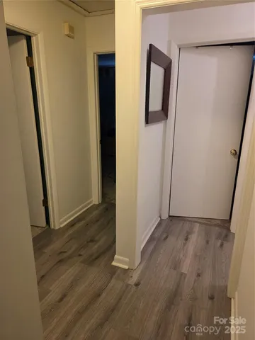 an empty room with wooden floor and entrance