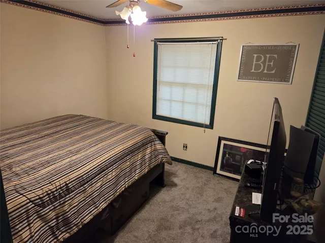 a bedroom with a bed and a flat tv screen on dresser
