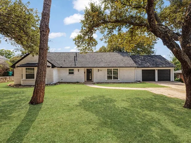 a view of a house with a yard and tree