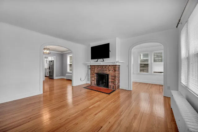 wooden floor fireplace and windows in an empty room