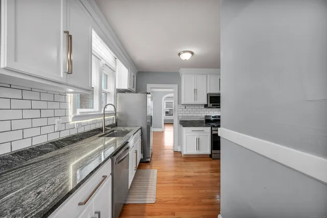 a kitchen with stainless steel appliances granite countertop a stove a sink and a refrigerator
