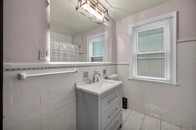 a bathroom with a granite countertop sink and a window