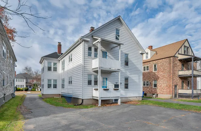 a view of a house with a yard and sitting area