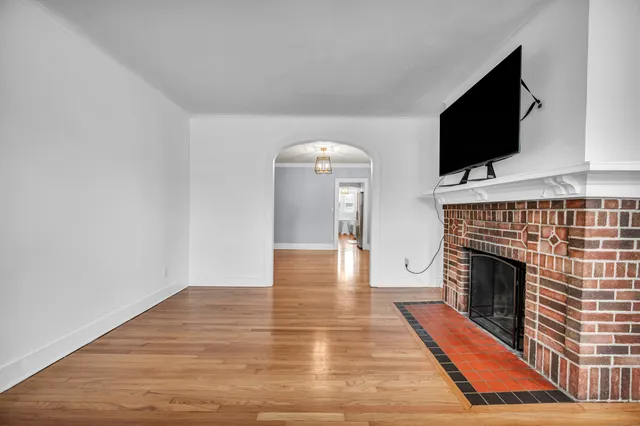 a view of empty room with wooden floor and fireplace