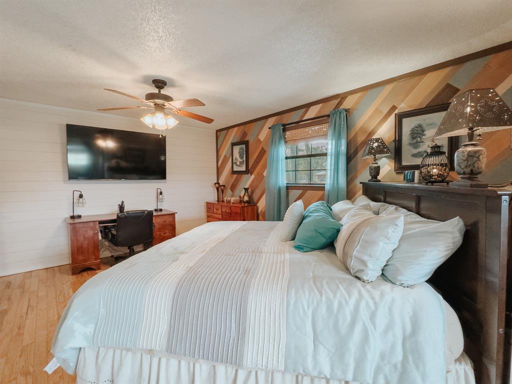 205 Peach Tree Road Mabank, TX 75156 - Photo 16 of 40 a bedroom with a bed and a flat screen tv