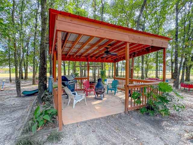 a view of a patio with table and chairs under an umbrella