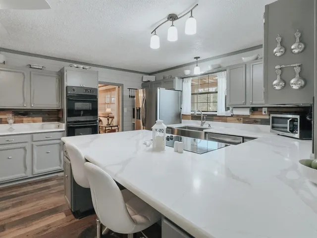 a large kitchen with kitchen island a stove a sink a dining table and chairs