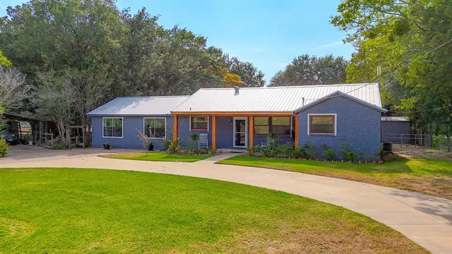 a front view of a house with a yard and trees