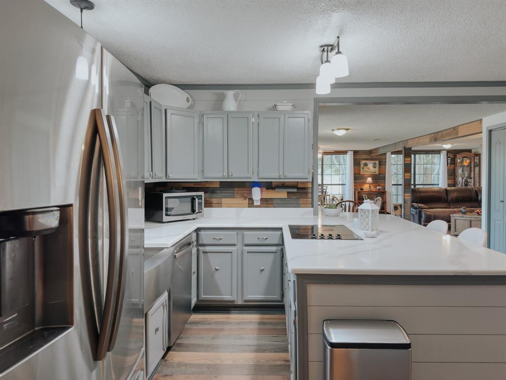 205 Peach Tree Road Mabank, TX 75156 - Photo 4 of 40 a kitchen with kitchen island a sink stainless steel appliances and cabinets
