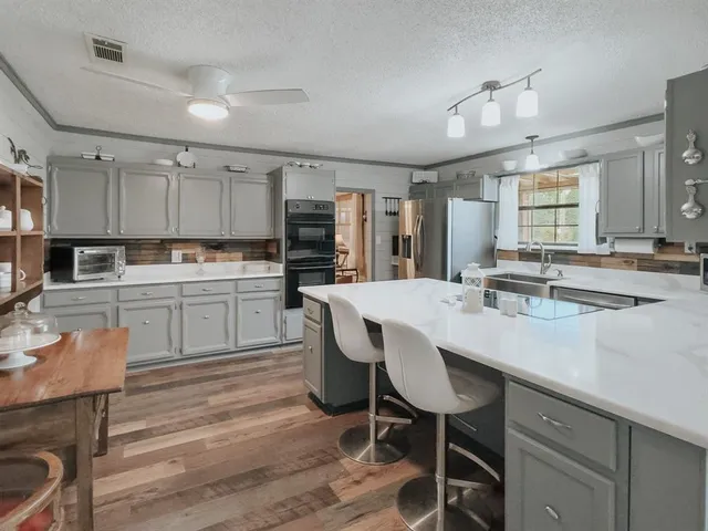 a kitchen with a table chairs microwave and cabinets