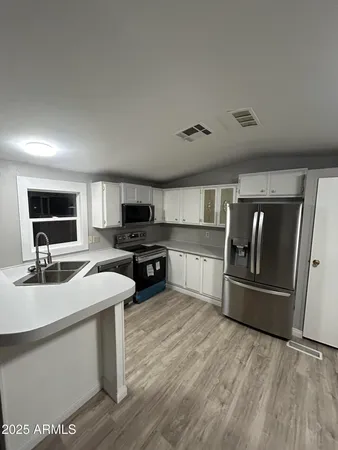 a kitchen with a sink a stove and a wooden cabinets