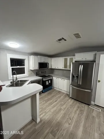 a view of empty room with wooden floor and window