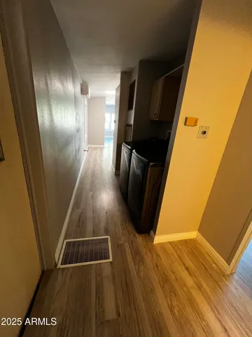 a view of a hallway with wooden floor and staircase