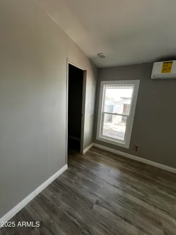 an empty room with wooden floor and staircase