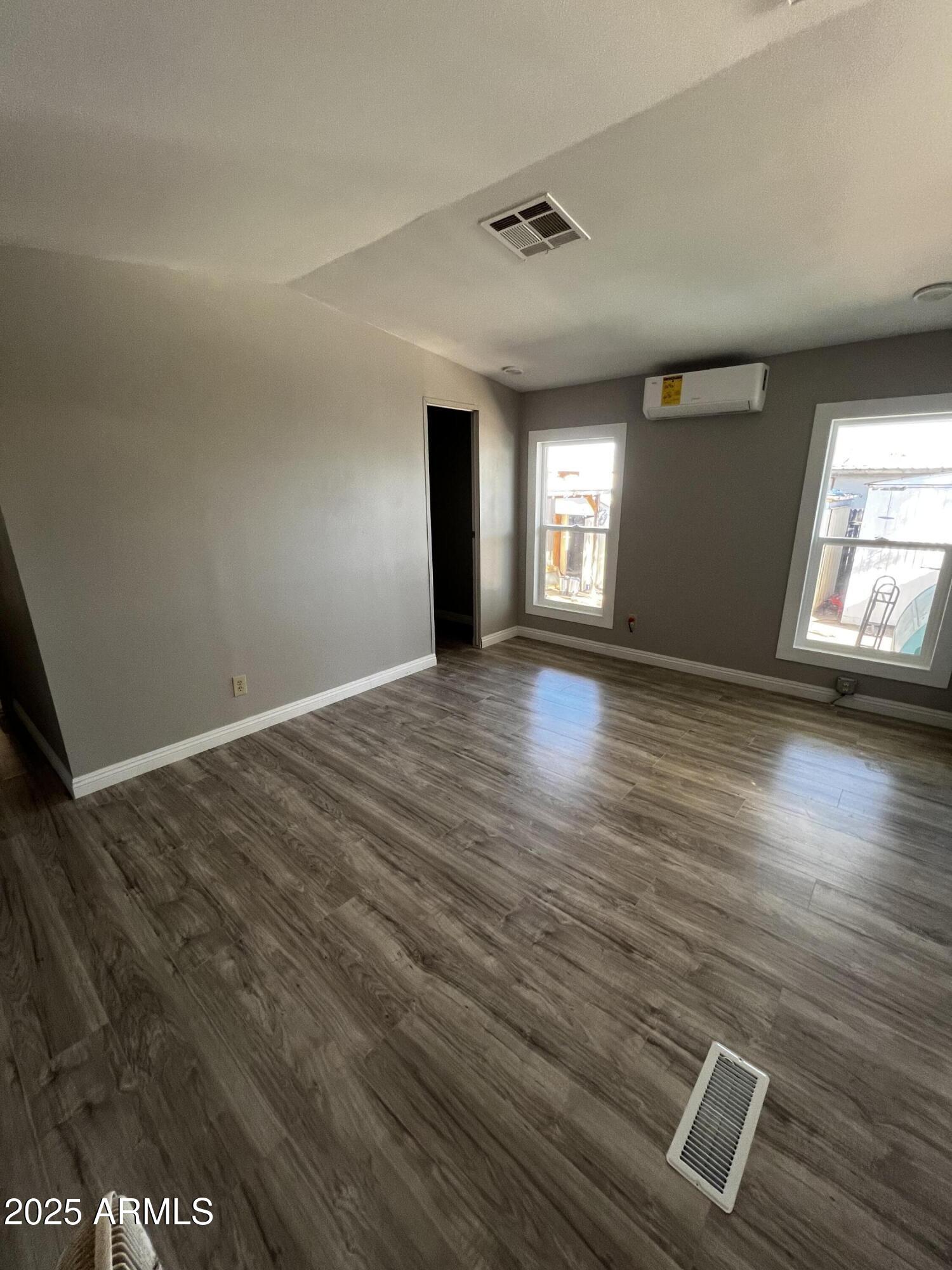 11201 East Jupiter Drive Apache Junction, AZ 85120 - Photo 27 of 35 an empty room with wooden floor and windows