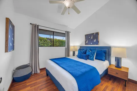 a bedroom with a large bed and a chandelier