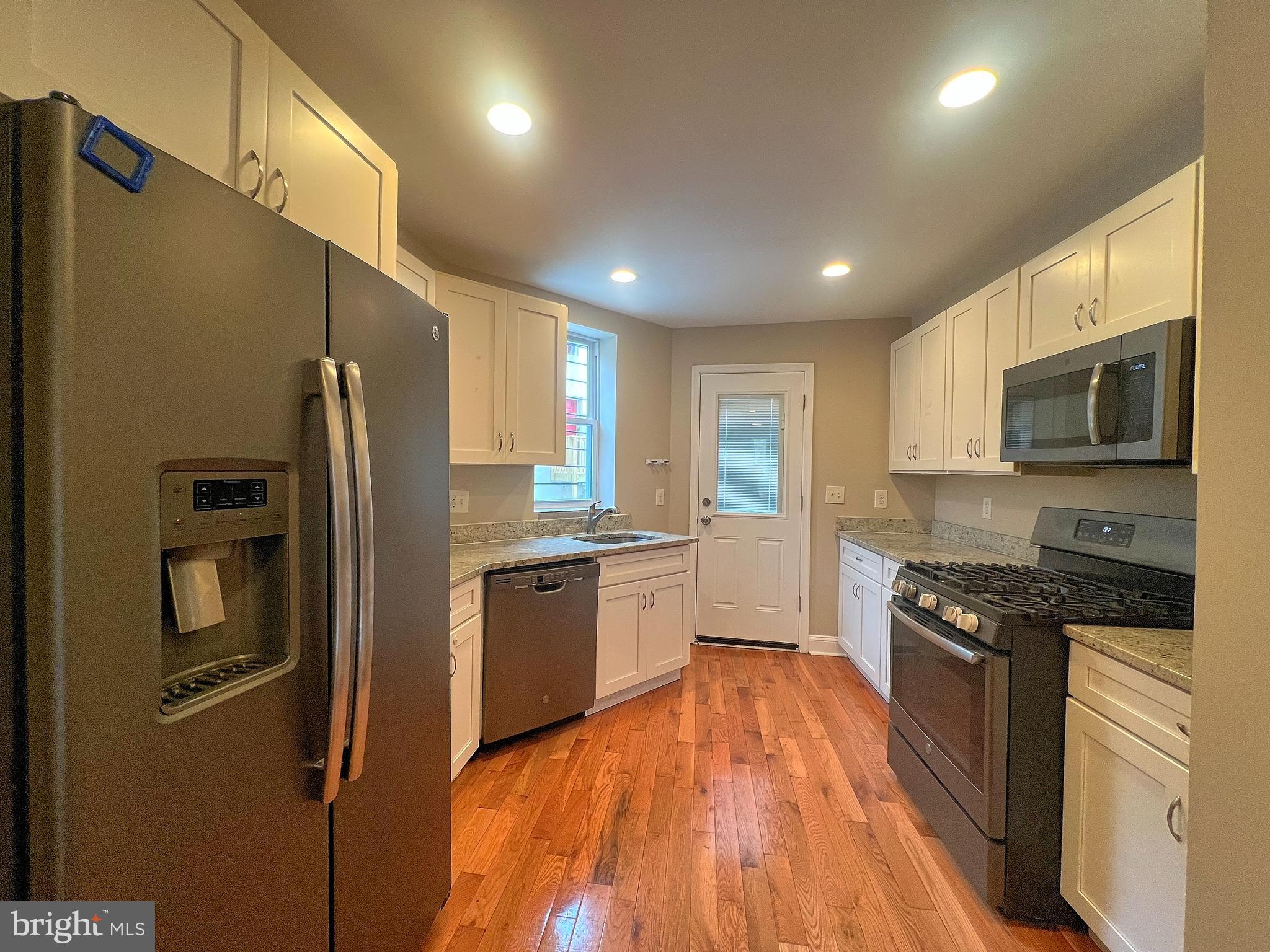 1234 West Cross Street Baltimore, MD 21230 - Photo 4 of 19 a large kitchen with stainless steel appliances granite countertop a stove a sink and a refrigerator