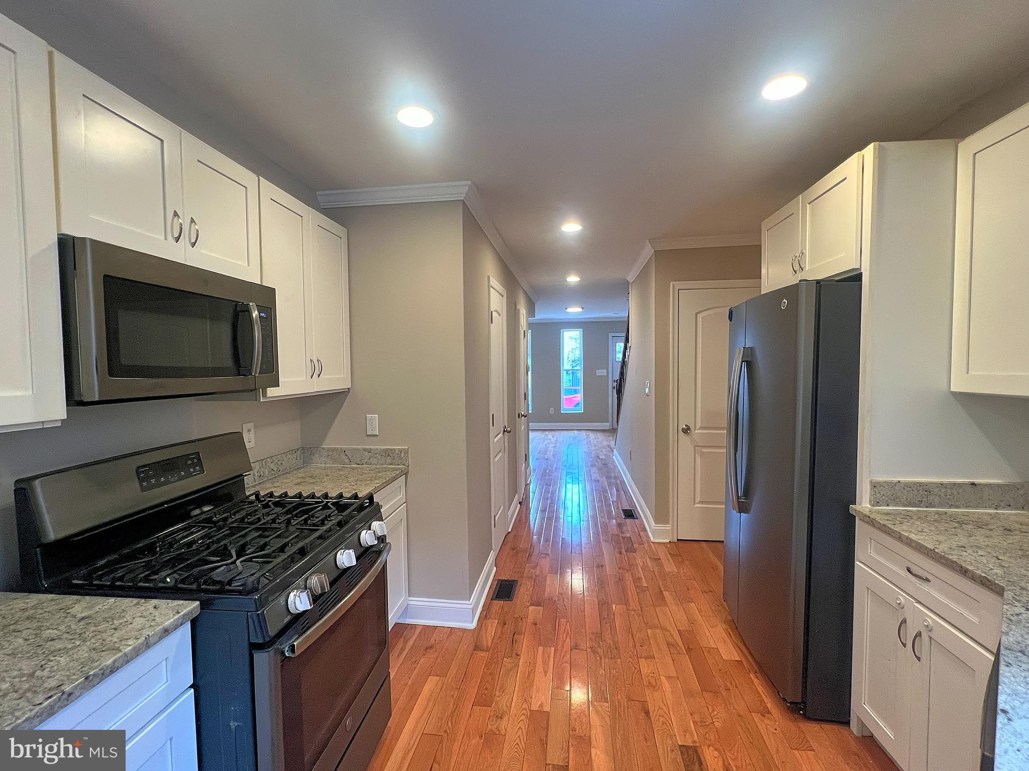1234 West Cross Street Baltimore, MD 21230 - Photo 5 of 19 a kitchen with a refrigerator and a stove top oven