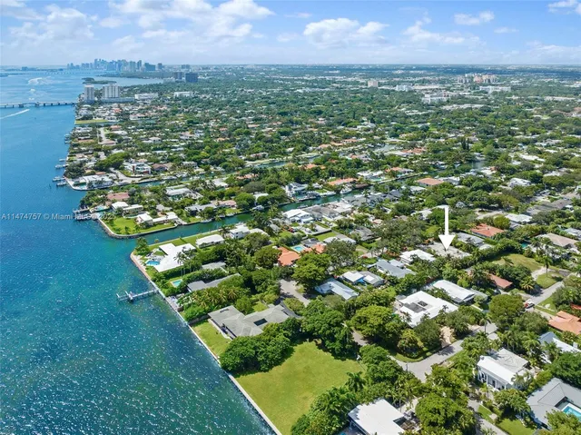 an aerial view of residential houses with outdoor space and trees