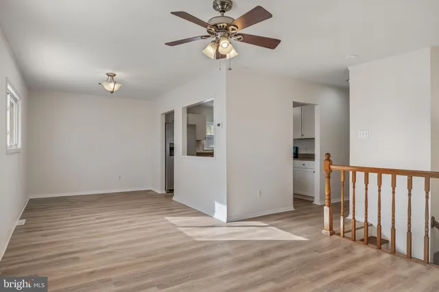 a view of a livingroom with wooden floor and a ceiling fan