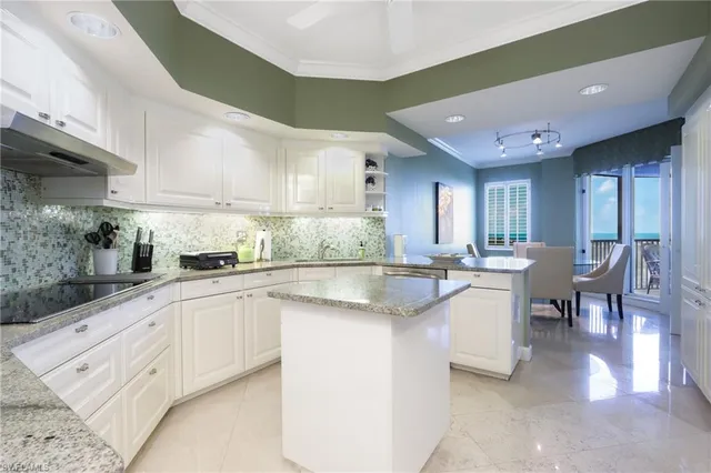 a kitchen with cabinets a sink and chairs