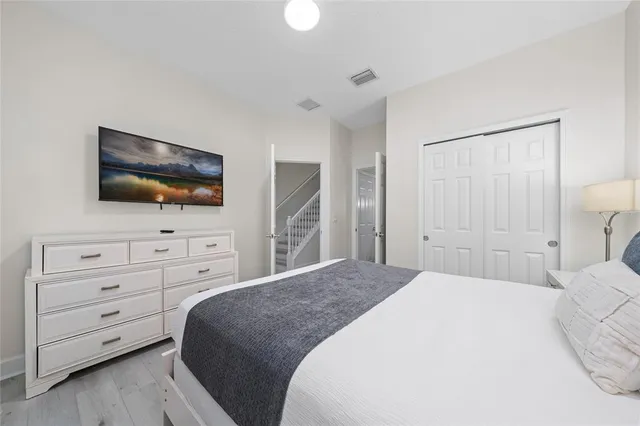 a bedroom with a bed a flat screen tv and a chandelier