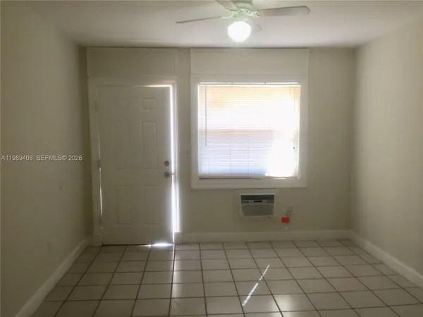 an empty room with windows and mirror