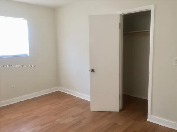 an empty room with wooden floor and closet