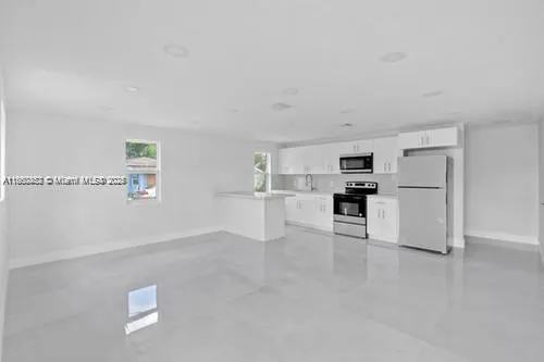 a view of kitchen with furniture and refrigerator