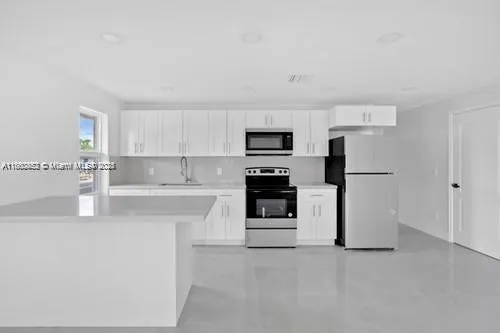 a kitchen with stainless steel appliances a refrigerator sink and microwave