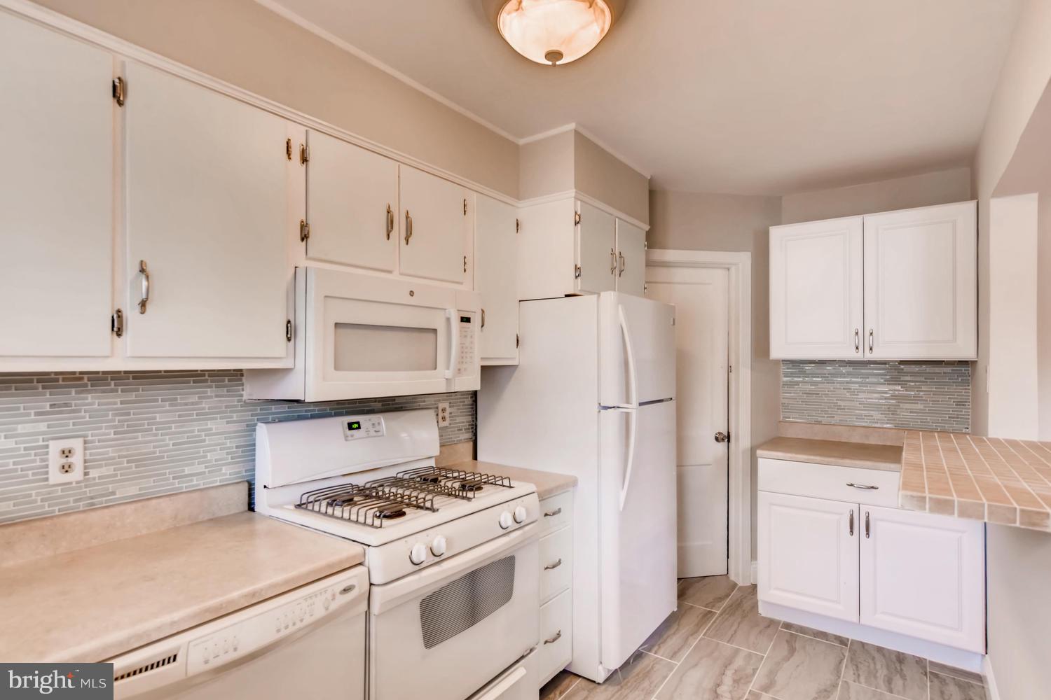 8546 Water Oak Road Baltimore, MD 21234 - Photo 7 of 28 a kitchen with white cabinets and white appliances
