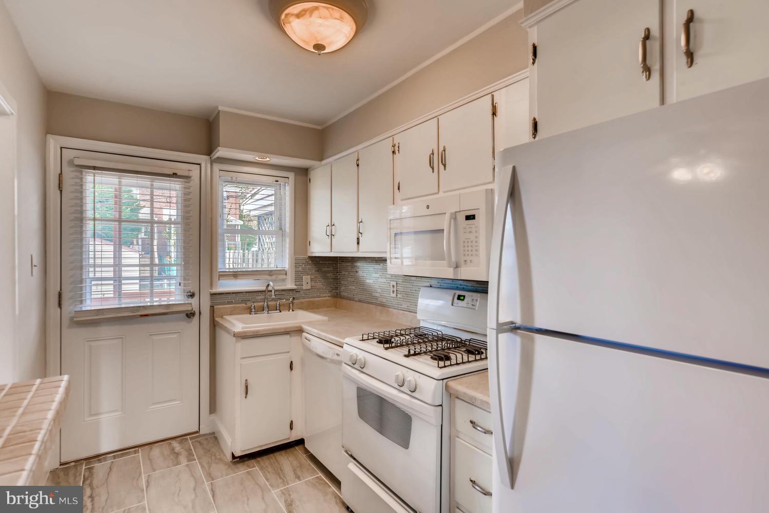 8546 Water Oak Road Baltimore, MD 21234 - Photo 10 of 28 a kitchen with white cabinets and white appliances