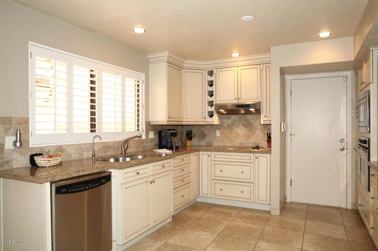7249 East Maverick Road Scottsdale, AZ 85258 - Photo 13 of 26 a kitchen with a sink stove and cabinets
