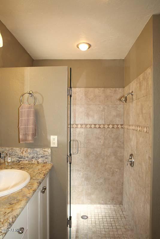 7249 East Maverick Road Scottsdale, AZ 85258 - Photo 19 of 26 a bathroom with a granite countertop bathtub shower sink and mirror