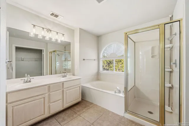 a bathroom with a tub sink shower and mirror