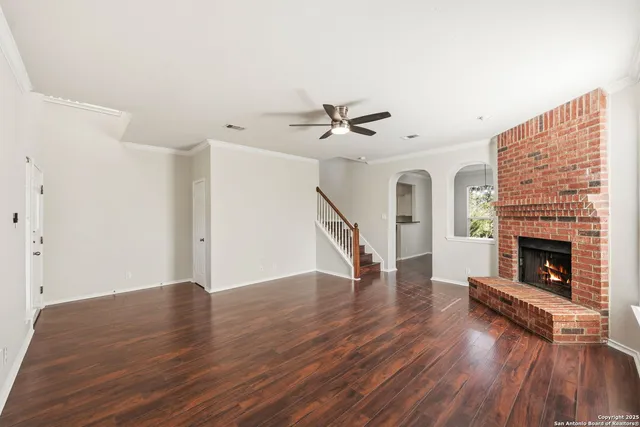 a view of a livingroom with wooden floor and a fireplace
