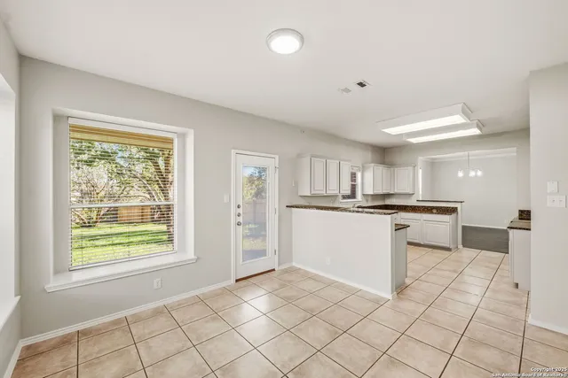 a kitchen with white cabinets and appliances