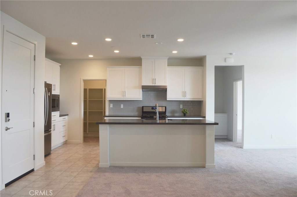 a kitchen with stainless steel appliances granite countertop a refrigerator a stove and a sink