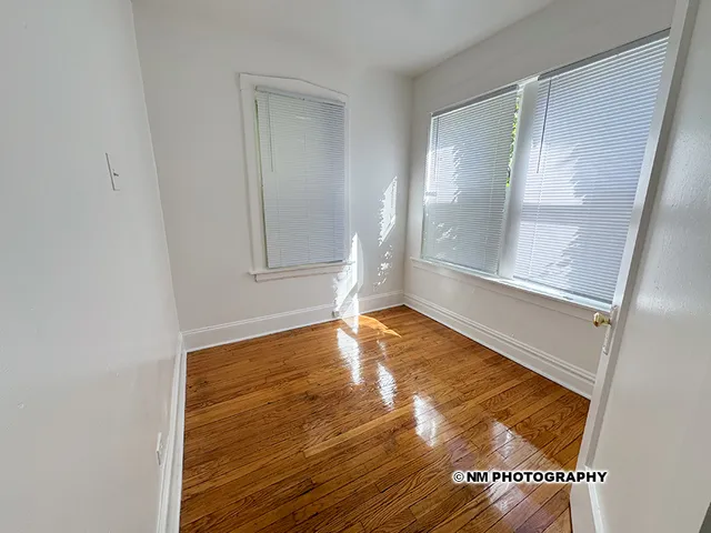 a view of empty room with wooden floor