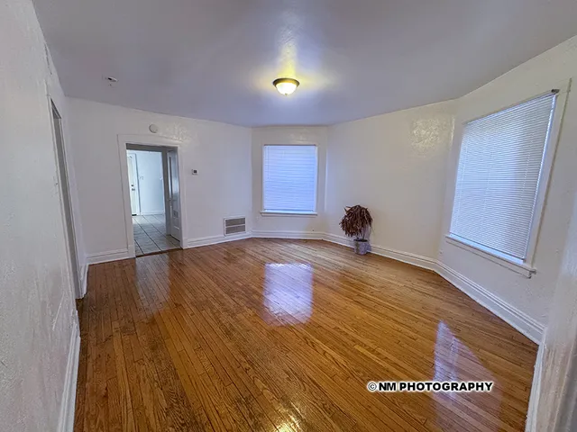 a view of empty room with wooden floor