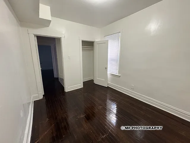 an empty room with wooden floor and closet